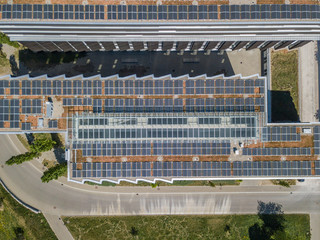 Aerial view of building roof with photovoltaic panel for power generation with sunlight. Concept of clean energy for buildings.