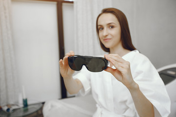 Woman in a cosmetology studio. Girl in a safety glasses.