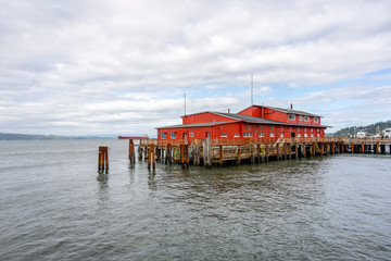 Old pier with wooden flooring and an administrative building for pilot ships in Astoria at the mouth of the Columbia River