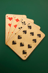 Old playing cards on a green background.