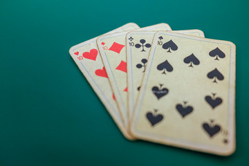 Old playing cards on a green background.