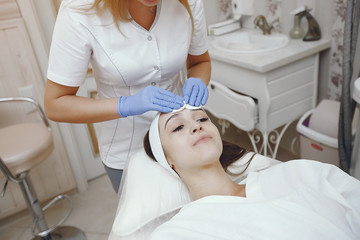 Cosmetologist treats client's skin. Woman with cosmetologist. Lady in a beauty studio.