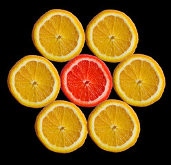 Orange slices laid out in a circle and one red in the center.