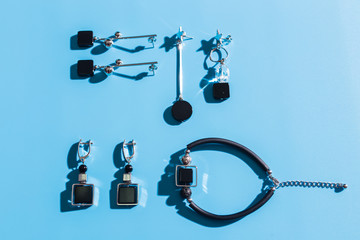 Women's Jewelry. Trendy jewelry on blue background. Flat lay, top view.