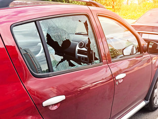 Broken glass on the passenger door of a passenger car parked. The concept of crime of car theft,...