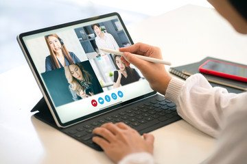 Business woman working on laptop computer at home during quarantine for coronavirus. VDO conference call with business partner group. Work from home and social distancing concept.