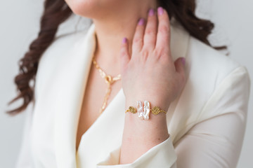 Close-up portrait of beautiful young woman with elegant hairstyle and luxurious jewelry and bijouterie.