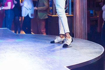 Dancing shoes feet and legs of male ballroom and latin salsa dancer dance teacher on the stage. Social dance, bachata solo and kizomba concept - obrazy, fototapety, plakaty