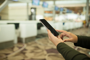 Hand using smartphone at ticketing counters