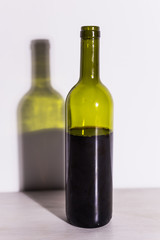 Shadow of wine glass in dark light.
