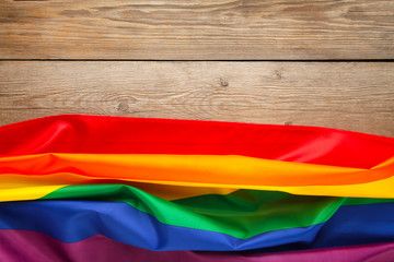 Rainbow LGBT flag on grey wooden background with copy space