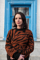 woman on the background of the window. brunette outside a residential building