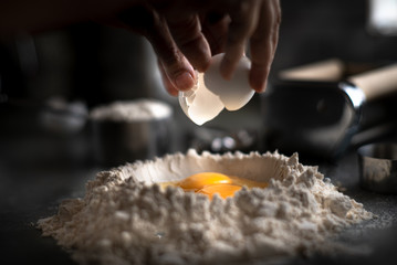 Process of making homemade wholewheat pasta in a kitchen with pasta sheet roller. Close up view. Dark photography