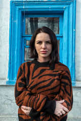 woman on the background of the window. brunette outside a residential building