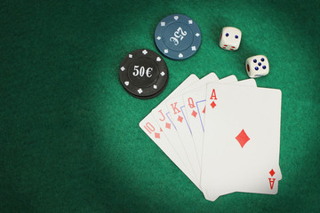 casino elements-dice, chips, cards-a combination of Royal flush on a green felt table