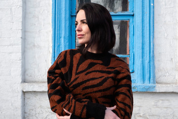 woman on the background of the window. brunette outside a residential building