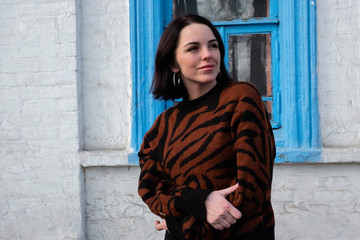 woman on the background of the window. brunette outside a residential building