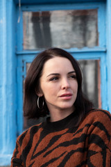 woman on the background of the window. brunette outside a residential building