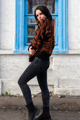 woman on the background of the window. brunette outside a residential building