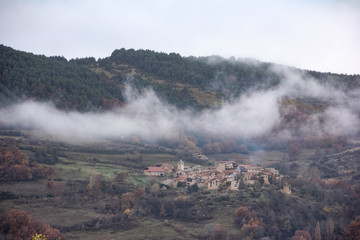Small village in the middle of the mountain with vegetation and clouds on a cold day