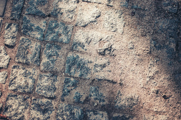 Granite cobblestone pavement background in the city. Full frame of regular square cobblestones in lines. Natural stone textured background.