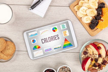 Organic food and tablet pc showing CALORIES inscription, healthy nutrition composition