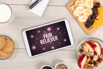 PAIN RELIEVER concept in tablet pc with healthy food around, top view