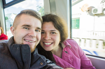 Young couple on vacation in Europe on the train take photo selfie.