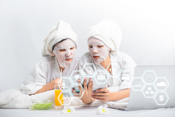 Obraz na płótnie Canvas Two Asian woman cosmetologist applying mask on face in spa salon and she use tablet application together.