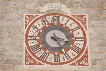 Fototapeta na wymiar The clock painted and recently restored outside the bell tower of the church in Tiso..