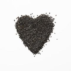 Basil seeds in shape of heart on white. Square image.