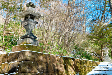 Fototapeta na wymiar Cultural architecture sculpture of Japanese stone lion and lantern at YUZAWA shrine in Noboribetsu town, Hokkaido, Japan