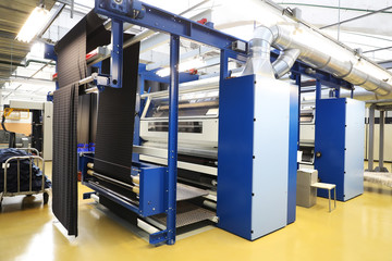 In the foreground, fabric for making clothes . Factory for the production of threads and fabrics