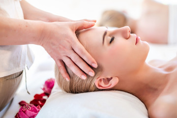 Obraz na płótnie Canvas Beautiful young attractive Caucasian woman having head massage by Thai Masseur in spa salon. Beauty treatment and body care lifestyle concept
