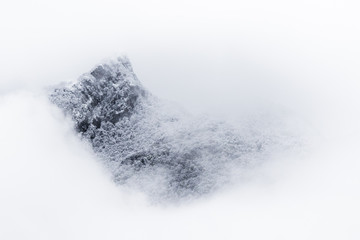mountain behind clouds after snow
