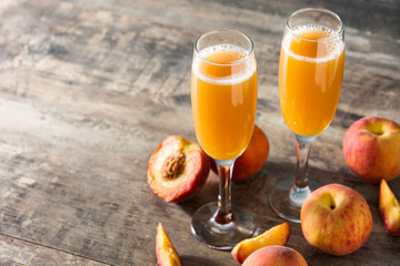 Bellini champagne cocktail in crystal glass on wooden table. Copy space