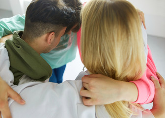Happy smiling friends, group of young people standing and embracing together