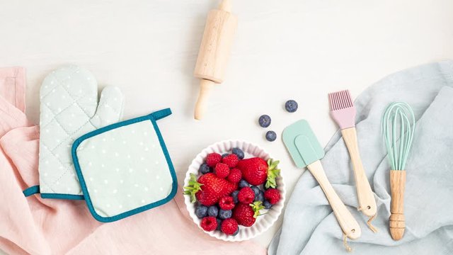 Stop motion animation of kitchen utensils, baking accessories and berries with text Bake it. Home cooking, online cooking classes, recipe concept