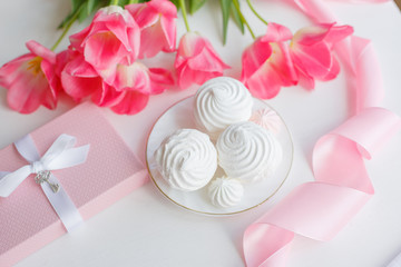 postcard good morning. Still life :  a bouquet of pink tulips, marshmallows on a light background near the window.
