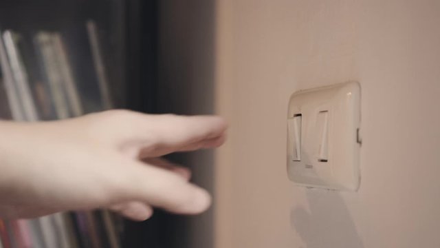 4K Close up hand switch off electric light . Concept of energy and power saving.