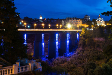 Illuminated bridge in the old town with trees