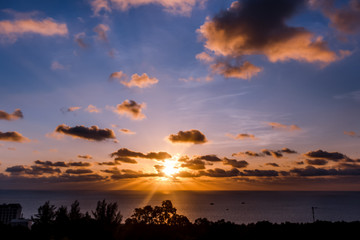 Evening sky at sunset background. Clouds hanging above horizon. Majestic cloudscape in blue, orange, violet shades