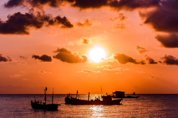 Sunset over the sea. Ships on the water, sun and clouds