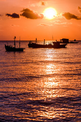 Fototapeta na wymiar Sunset on the beach. Sea, ships and orange sky