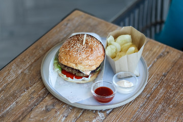 hamburger and fries in plate on table.