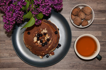 .morning pancakes .fritters with honey nuts and currants lilac copy space