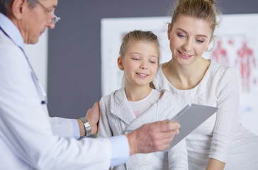 Fototapeta premium Little girl with her mother at a doctor on consultation