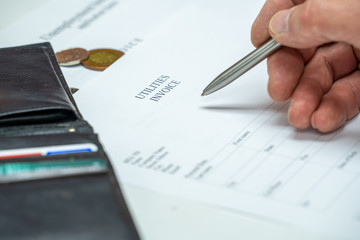 Man signs a utilities invoice with a ballpoint pen in the office