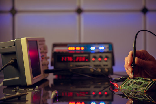 Debugging electronics device. PCB witch microcontroller in electronics laboratory