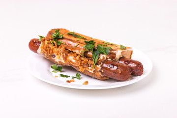 Double hot dogs with french brioche buns and caramelized onions with mayo sauce and ketchup.